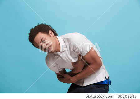 Young man overwhelmed with a pain in the stomach . Young man overwhelmed with a pain in the stomach . 39308585