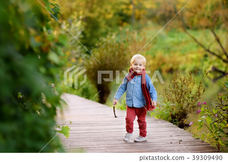 Little boy playing during stroll in the forest Little boy playing during stroll in the forest 39309490