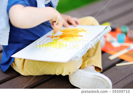 boy drawing with colorful paints in summer park 39309710