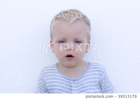Emotions. Surprised toddler against wall. Close-up Emotions. Surprised toddler against wall. Close-up 39313179