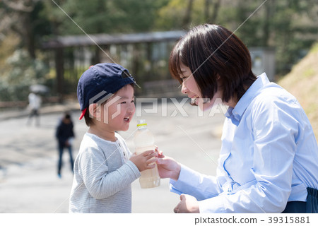 Parents and children drinking drinks in the park 39315881
