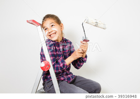 girl on building ladder using a brush for painting girl on building ladder using a brush for painting 39316948