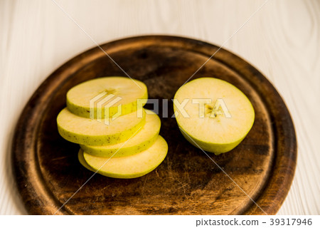 Green apple sliced with knife on cutting board Green apple sliced with knife on cutting board 39317946