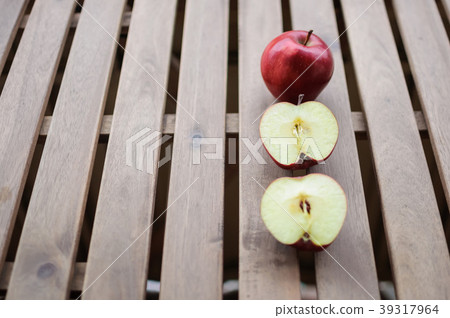 Apples whole and cut in halves on wooden surface Apples whole and cut in halves on wooden surface 39317964