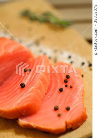 Sliced salmon fillet and pepper on cutting board 39318078