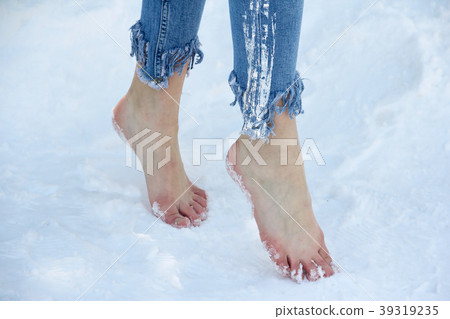 Slender beautiful girl feet close up in the snow. 39319235