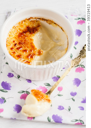Ramekin with creme brulee and spoon in the middle 39319413