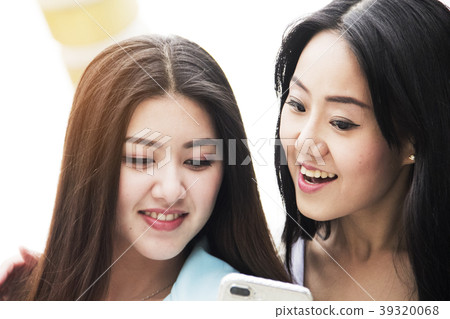 Beautiful Asia women playing on mobile phone. 39320068