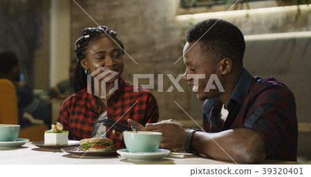 Relaxing black man and woman in cafe Relaxing black man and woman in cafe 39320401