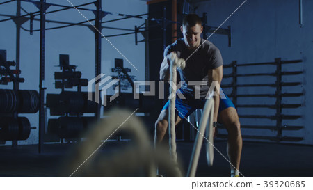 Athletic man working out with ropes in gym Athletic man working out with ropes in gym 39320685