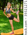 girl doing exercises on the mat in the park on the 39321271