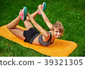 girl doing exercises on the mat in the park on the 39321305