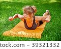 girl doing exercises on the mat in the park on the 39321332