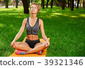 girl doing exercises on the mat in the park on the 39321346