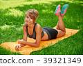 girl doing exercises on the mat in the park on the 39321349
