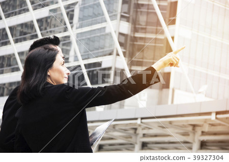Smart business woman standing over modern building Smart business woman standing over modern building 39327304