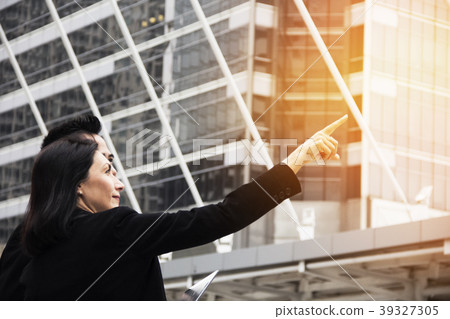 Smart business woman standing over modern building Smart business woman standing over modern building 39327305