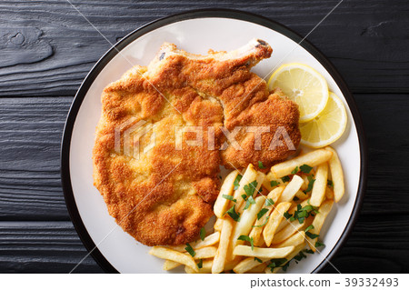veal cutlet Milanese with lemon and French fries 39332493