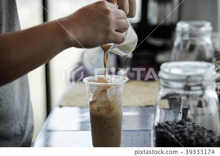 male barista poured coffee into a glass male barista poured coffee into a glass 39333174
