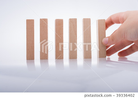 Hand holding wooden domino Hand holding wooden domino 39336402