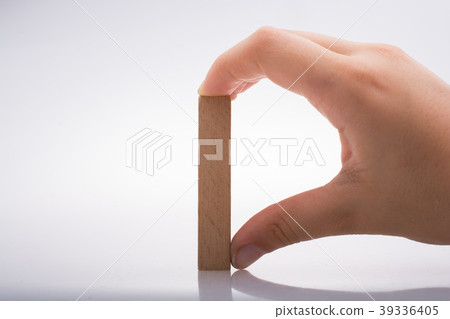Hand holding wooden domino Hand holding wooden domino 39336405