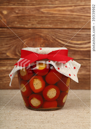 Jar of pickled cheese stuffed peppers on table 39339982