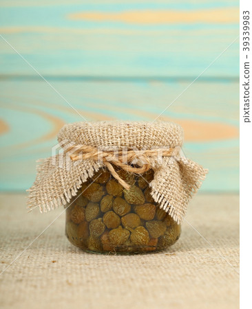 Jar of pickled green capers on table 39339983