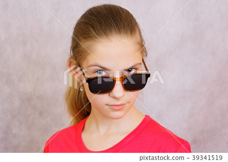 A teenage girl in the pinhole glasses.Studio shot A teenage girl in the pinhole glasses.Studio shot 39341519