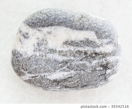 tumbled gray Gneiss pebble on white marble 39342516