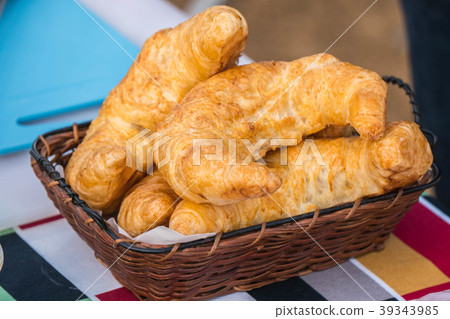 fresh croissants in a basket on a wooden table 39343985