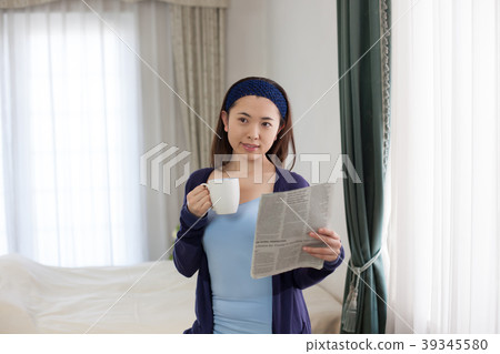 放鬆一個假日和讀報紙的婦女 放鬆一個假日和讀報紙的婦女 39345580