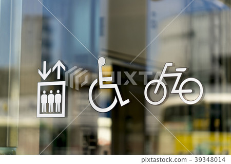 Picto signs affixed to the glass surface of the curtain wall: elevator wheelchair wheelchair bicycle parking lot 39348014