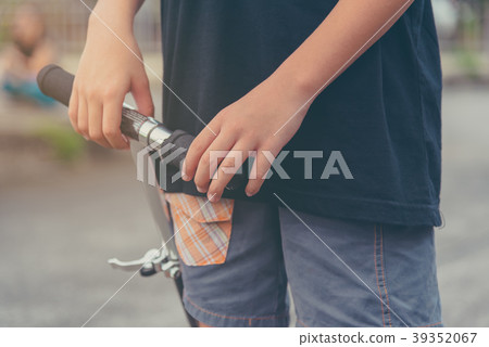 Asian boy playing scooter on street. Asian boy playing scooter on street. 39352067