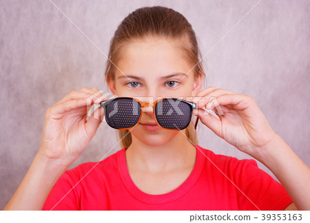 The girl is preparing to try on training glasses The girl is preparing to try on training glasses 39353163