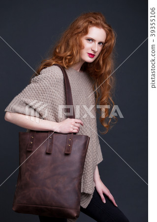 Red hair fashion model holding large leather bag Red hair fashion model holding large leather bag 39355106