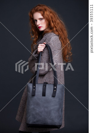 Red hair fashion model holding large leather bag Red hair fashion model holding large leather bag 39355111