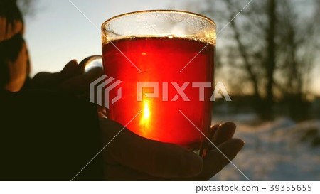 People pour a hot drink from a thermos into a 39355655