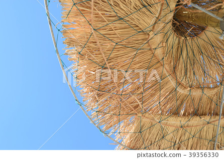 Straw parasols at the beach in summer Straw parasols at the beach in summer 39356330