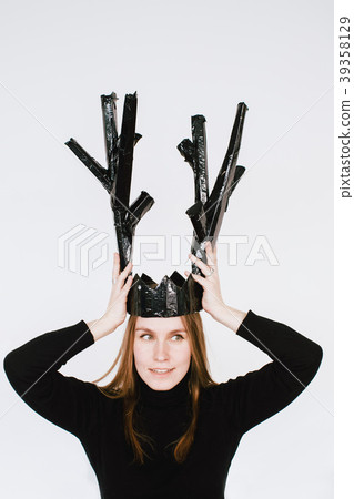 Woman putting a paper crown on her head 39358129