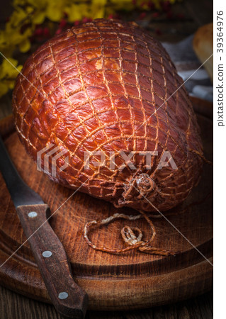 Whole ham on a wooden table. 39364976