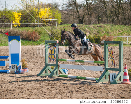 Girl jumping over hurdle on competition Girl jumping over hurdle on competition 39366332