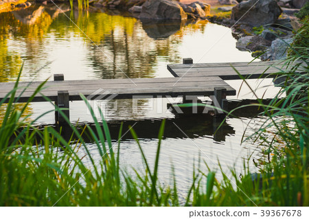 Japanese zig-zag garden bridge over a pond Japanese zig-zag garden bridge over a pond 39367678