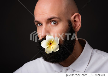 Portrait of unshaven man with beard with flower Portrait of unshaven man with beard with flower 39369301