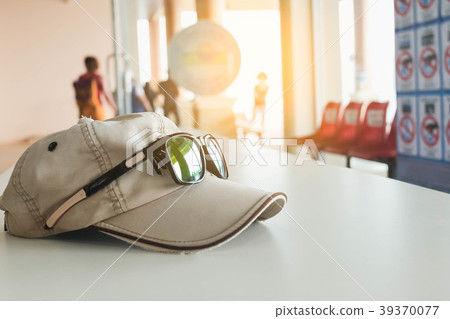 Hat and glasses on white table Hat and glasses on white table 39370077