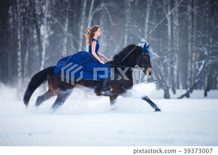 Young girl in dress riding horse on winter field Young girl in dress riding horse on winter field 39373007