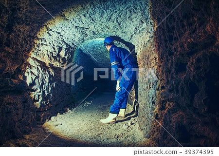 Staff in underground dome. Man with headlight  39374395
