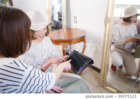 Woman pointing at tablet at beauty salon Woman pointing at tablet at beauty salon 39375121