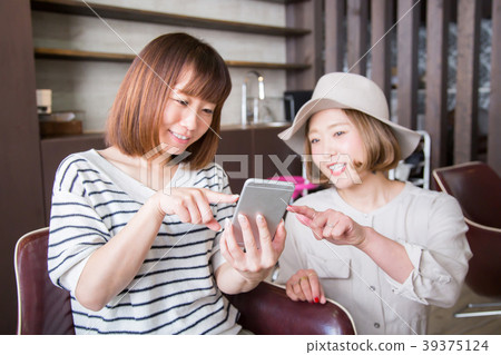 Woman pointing at smartphone at beauty salon Woman pointing at smartphone at beauty salon 39375124