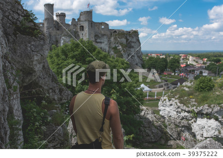 Man standing on the cliff,castle in the distance 39375222