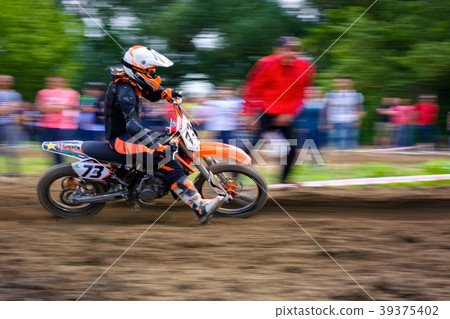 MX rider turns in a dirt. Motion blur with panning MX rider turns in a dirt. Motion blur with panning 39375402